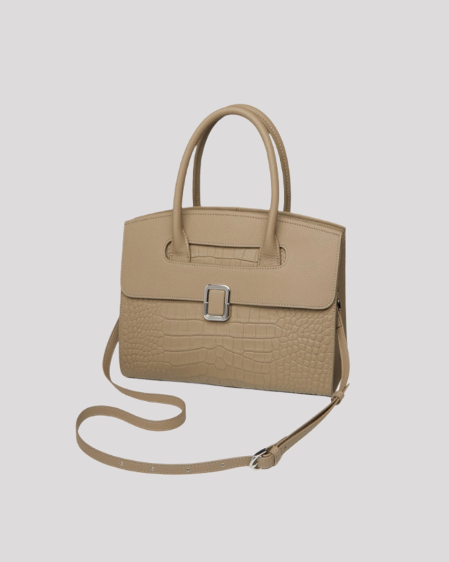 Front angle view of beige croc-embossed leather handbag highlighting structured silhouette and silver buckle