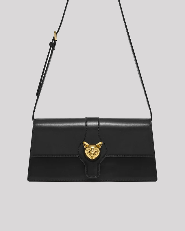 Front view of black leather shoulder bag by Bafelli with gold cat emblem clasp and sleek rectangular shape