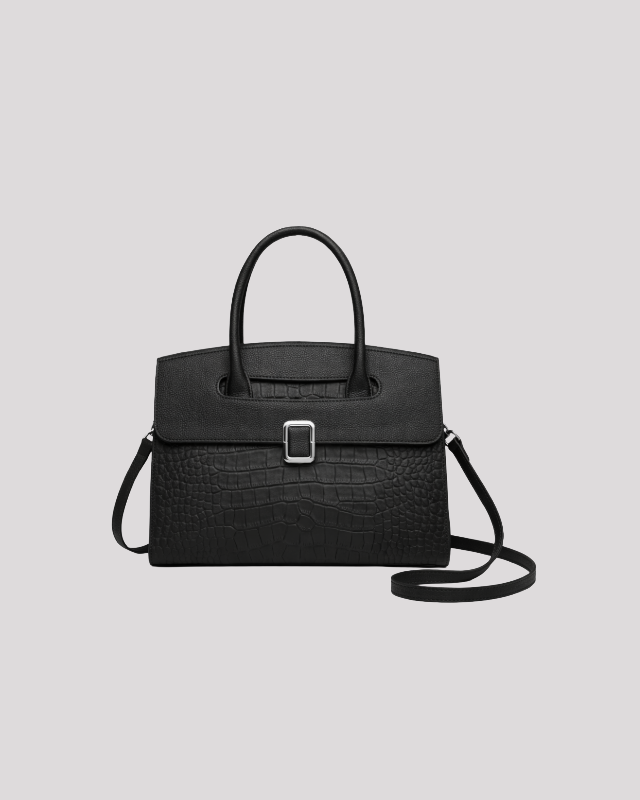Front view of black croc-embossed leather handbag with top handle, silver buckle detail and detachable shoulder strap