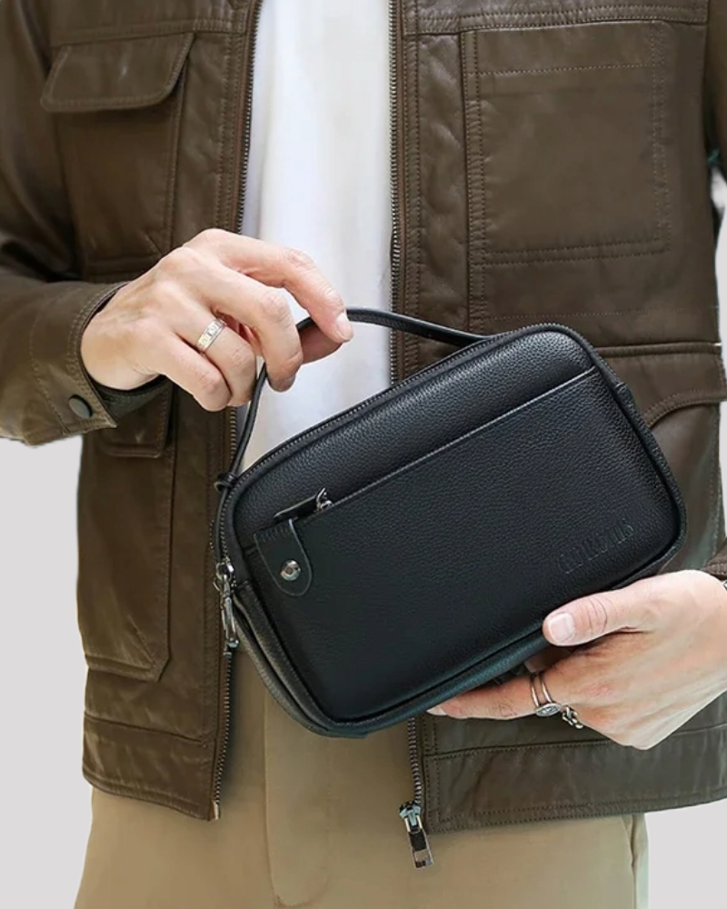 Man in brown leather jacket holding black leather clutch bag – lifestyle view