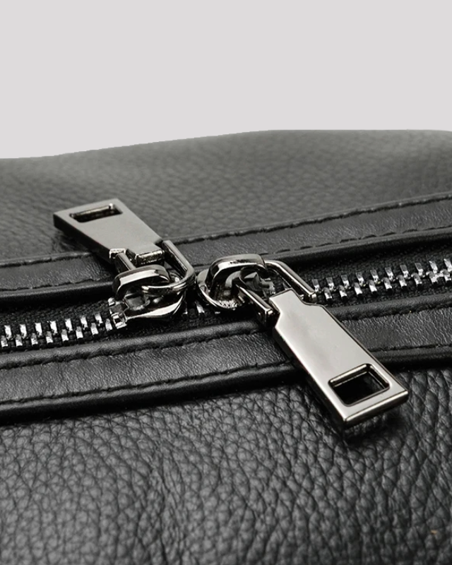 Close-up of silver zipper detail on black leather travel duffel bag
