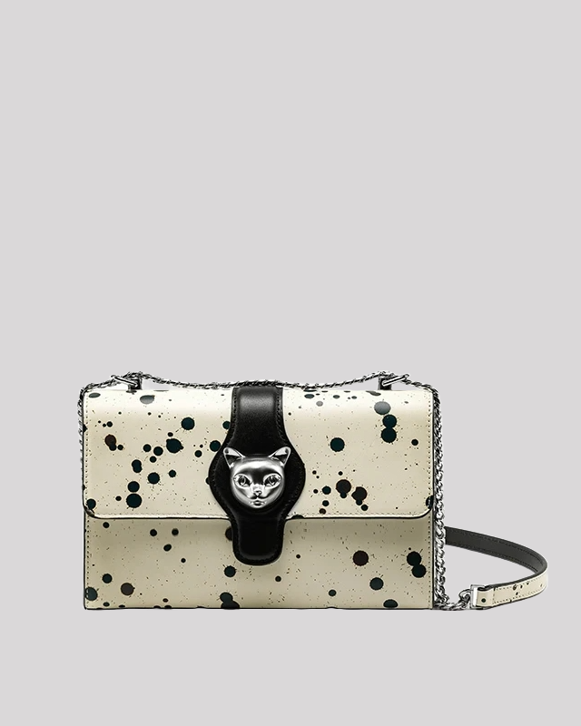 Front view of black splatter paint shoulder bag with silver cat clasp and black leather strap by Bafelli
