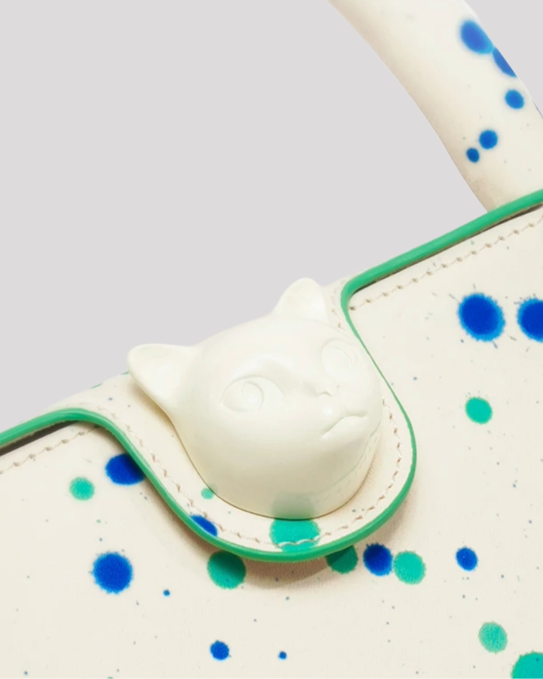 Close-up detail of cat head clasp on Blue Green Splatter Cat Bag by Bafelli with paint splatter accents