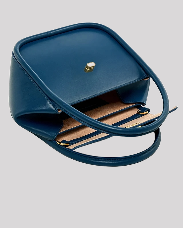 Open view of blue structured top handle bag by Bafelli showing interior compartments and suede lining