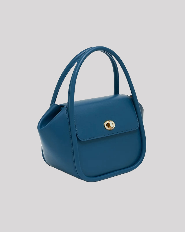 Side angle of blue structured top handle bag by Bafelli showing curved handles and elegant silhouette