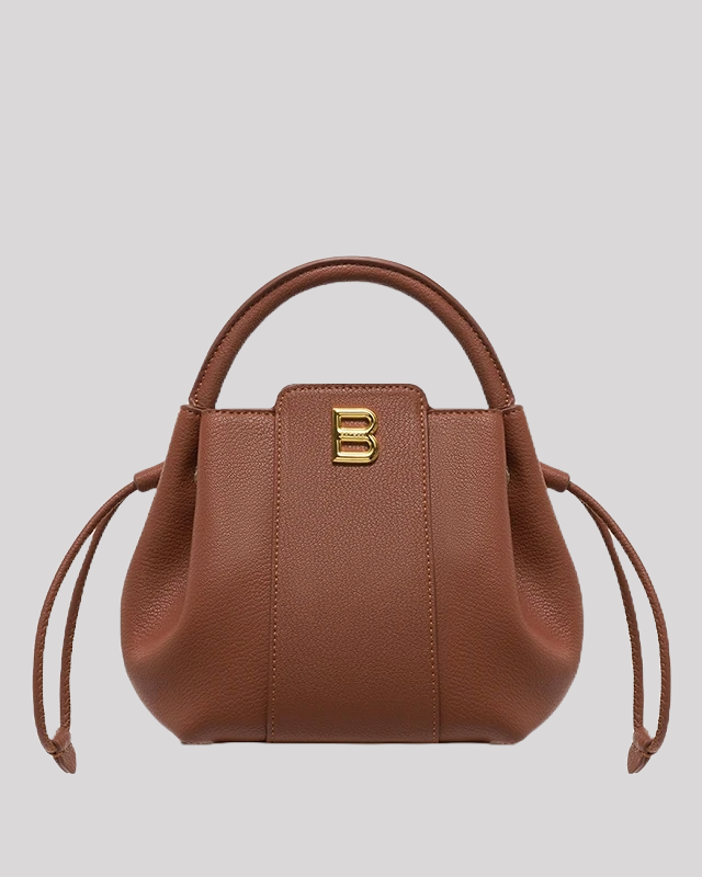 Front view of brown leather bucket bag with structured silhouette, gold B logo, and side drawstring details