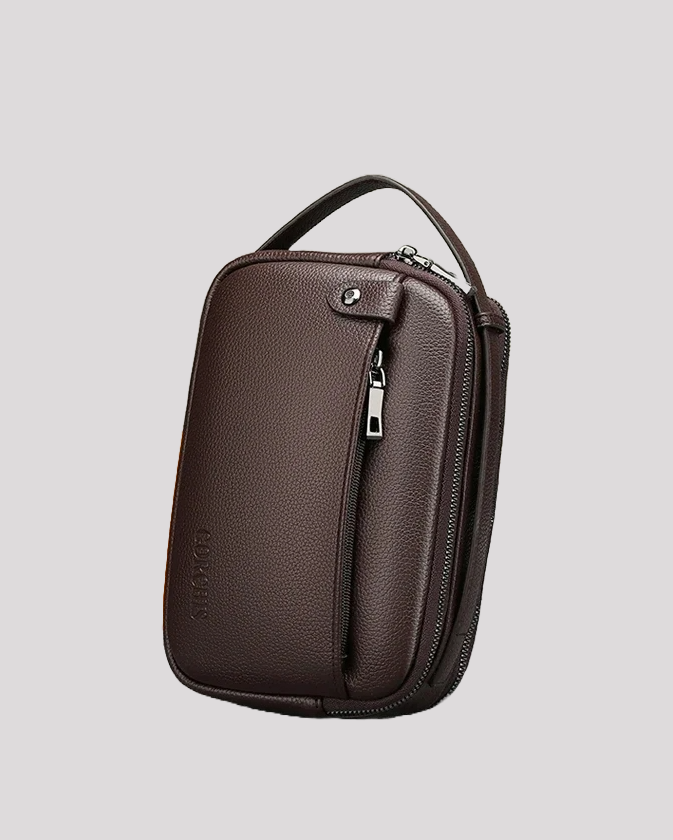 Angled view of brown leather men’s handbag standing upright with zipper detail
