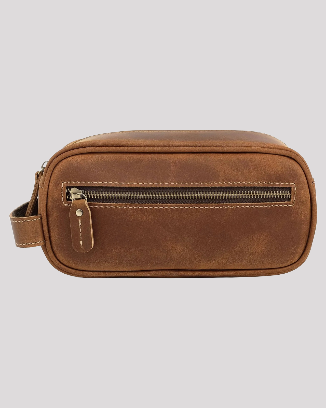 Front view of brown leather toiletry bag with visible zipper pocket and smooth stitching
