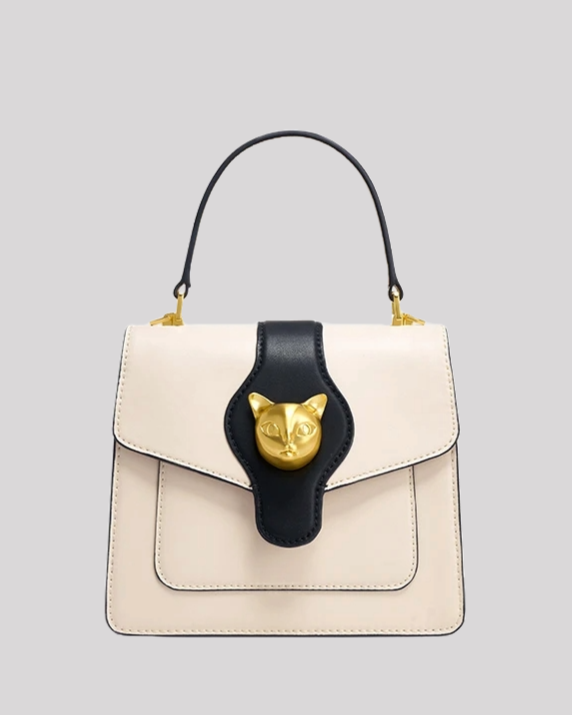 Front view of cream and black handle bag by Bafelli with structured silhouette and gold cat head clasp