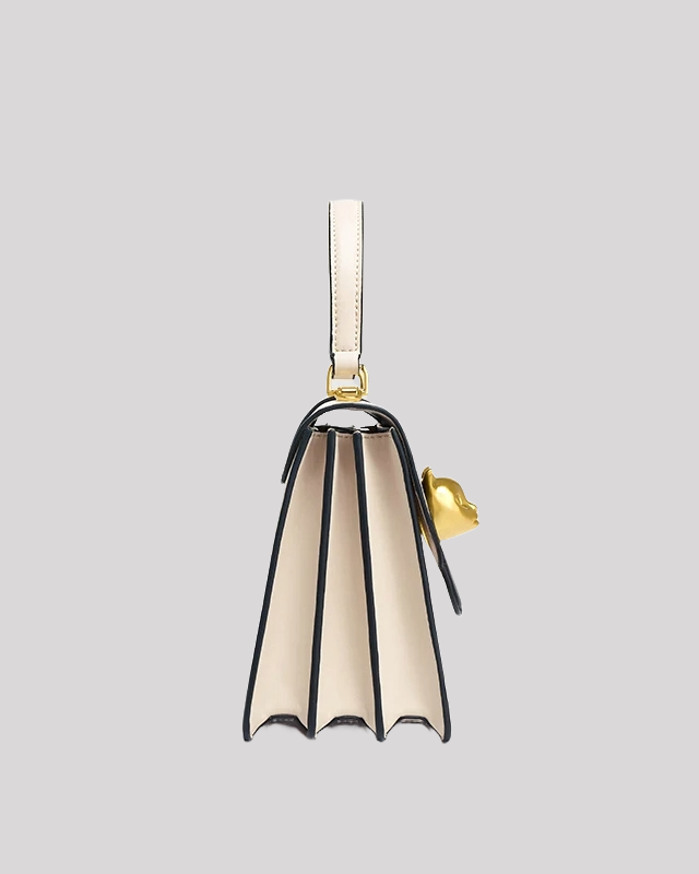 Side profile of cream and black handle bag by Bafelli with accordion-style compartments