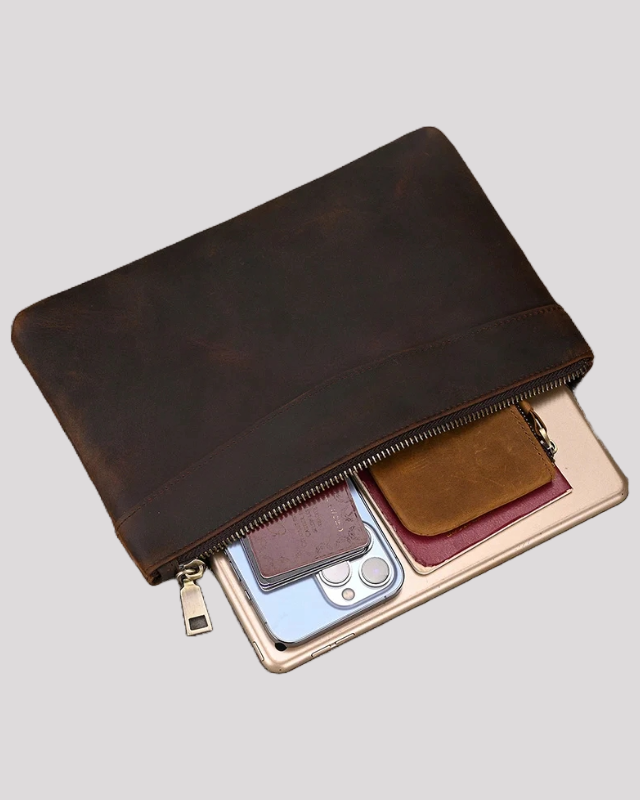 Dark brown leather clutch bag – half-open view with phone, wallet and tablet inside