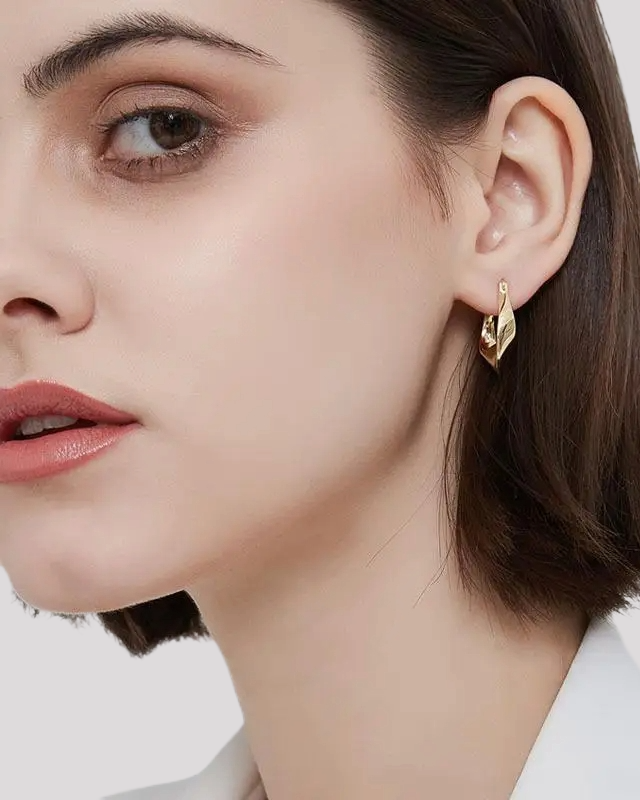 Woman wearing gold wavy hoop earrings – elegant styling
