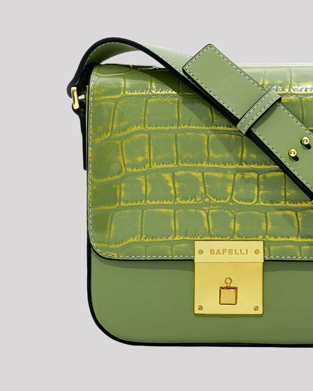 Close-up of green croc-embossed shoulder bag by Bafelli showing detailed leather texture and gold lock closure