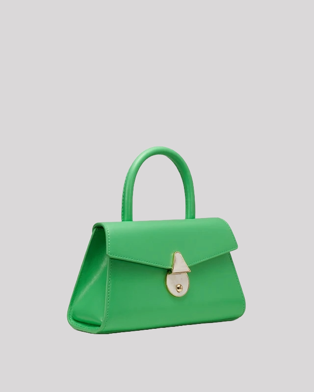 Side angled view of green mini top-handle bag by Bafelli with pearl clasp and trapeze design