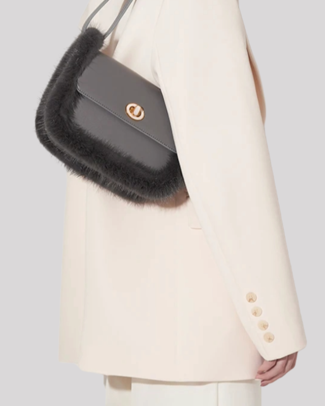 Model wearing grey fur-trim crossbody bag by Bafelli styled with cream blazer
