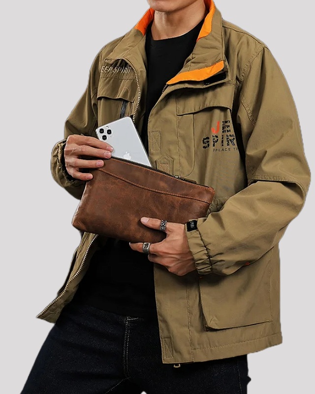Man holding mocha leather clutch bag with smartphone inside – lifestyle view