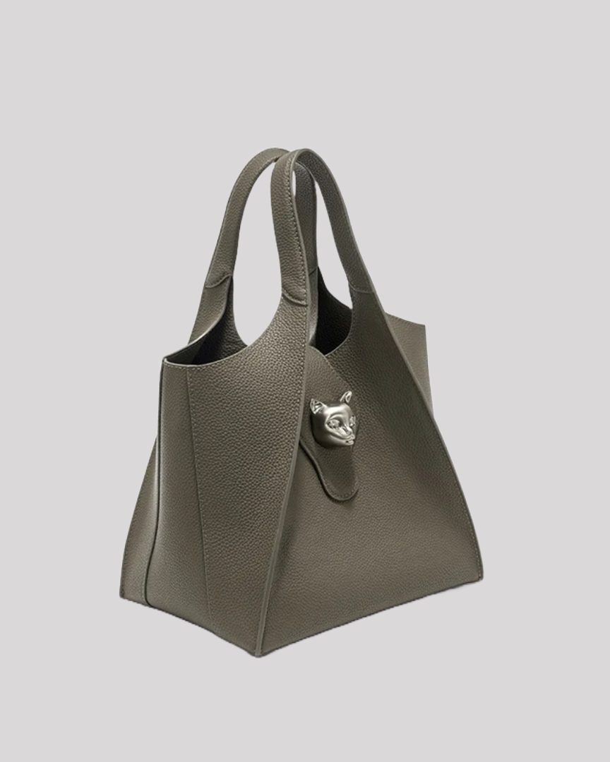 Side profile of structured olive green leather tote bag by Bafelli with curved silhouette and cat emblem clasp