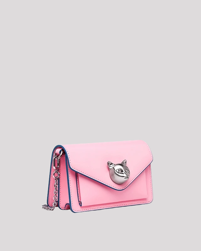 Side view of pink envelope crossbody bag by Bafelli featuring silver cat head closure and chain strap
