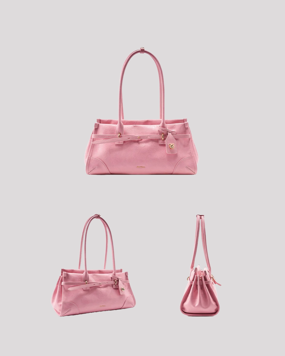 Angled view of pink leather shoulder bag by Bafelli with double handles and belt detail