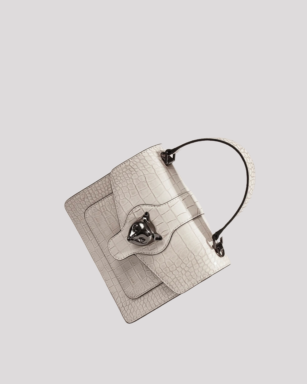 Angled top view of white croc-embossed handbag by Bafelli showing cat head clasp and structured flap