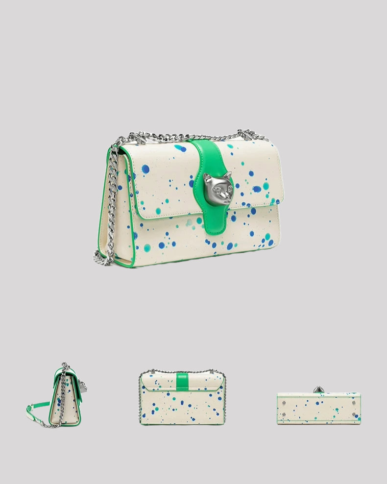 Side angle of white and green splatter crossbody bag with silver cat head clasp and chain strap