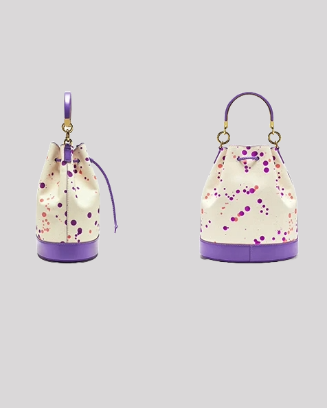 Side and back views of paint-splatter bucket bag by Bafelli featuring structured base, drawstring closure, and purple leather accents