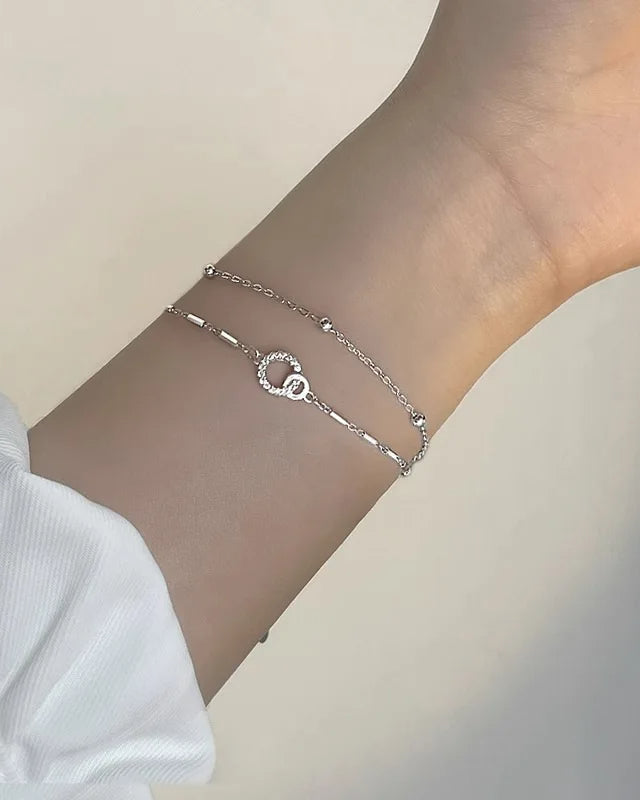 Women’s silver bracelet with heart and circle pendant – elegant wrist view with delicate chain
