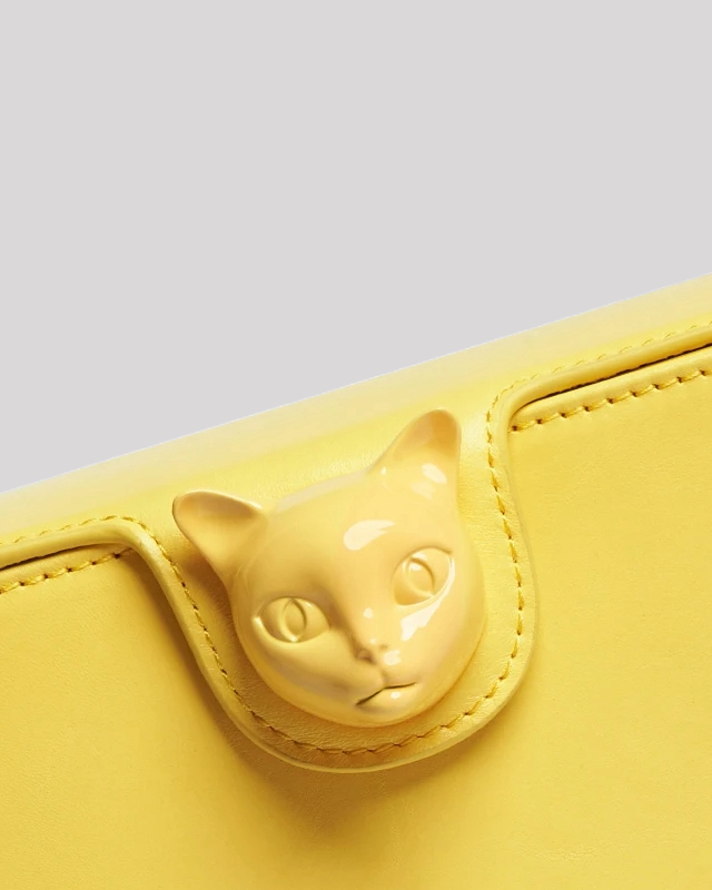 Close-up of yellow Bafelli bag showing detailed cat head clasp design