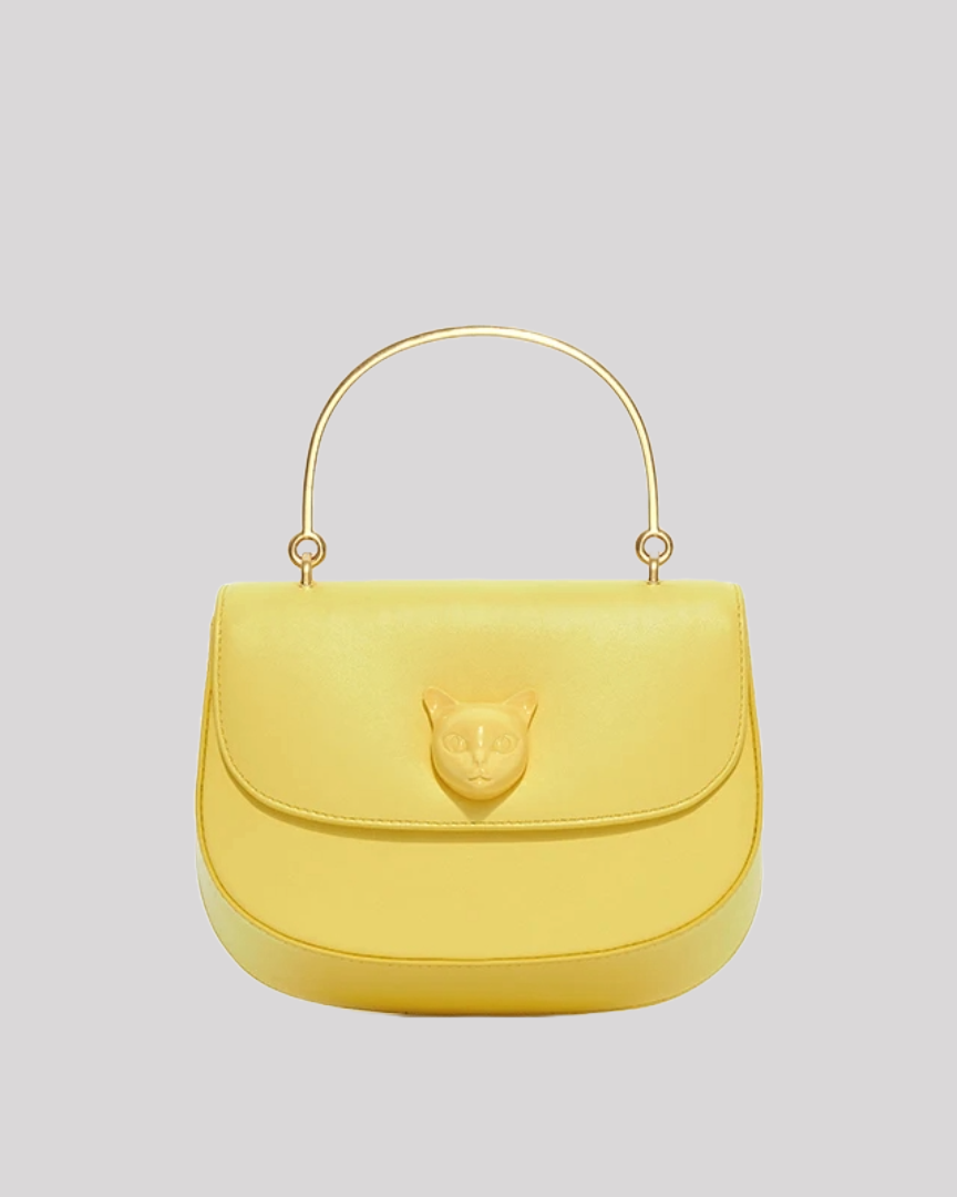 Front view of yellow leather handbag by Bafelli with embossed cat emblem and gold handle