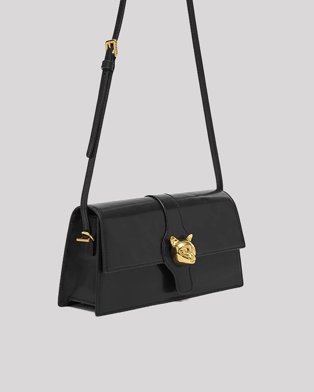 Side angle of black cat-emblem shoulder bag by Bafelli showing structured silhouette and adjustable strap