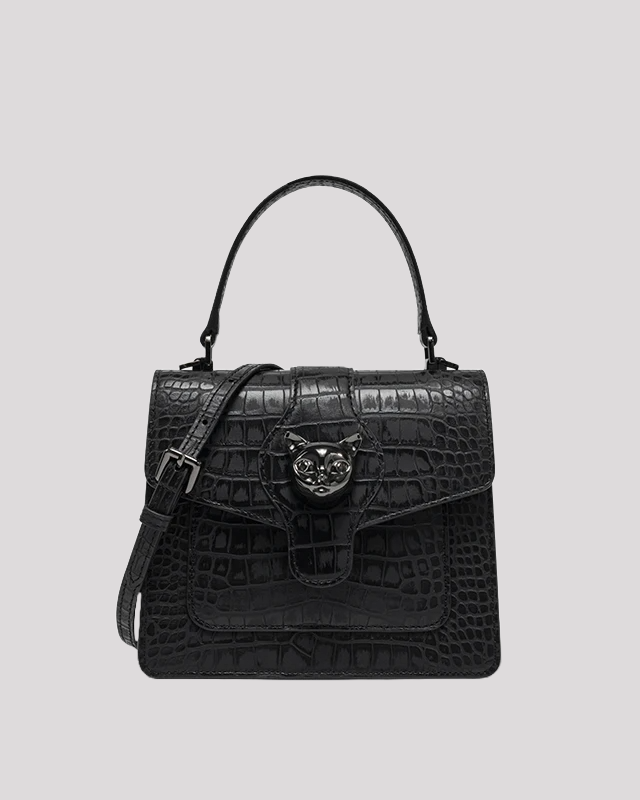 Front view of black croc-embossed leather handbag by Bafelli with cat head clasp and top handle