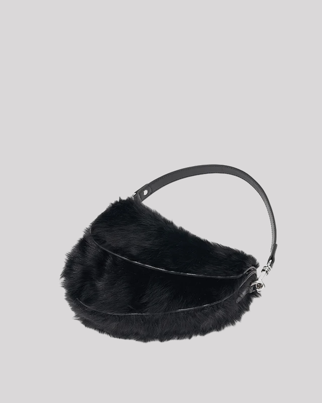 Angled view of black faux fur shoulder bag by Bafelli with soft structured design