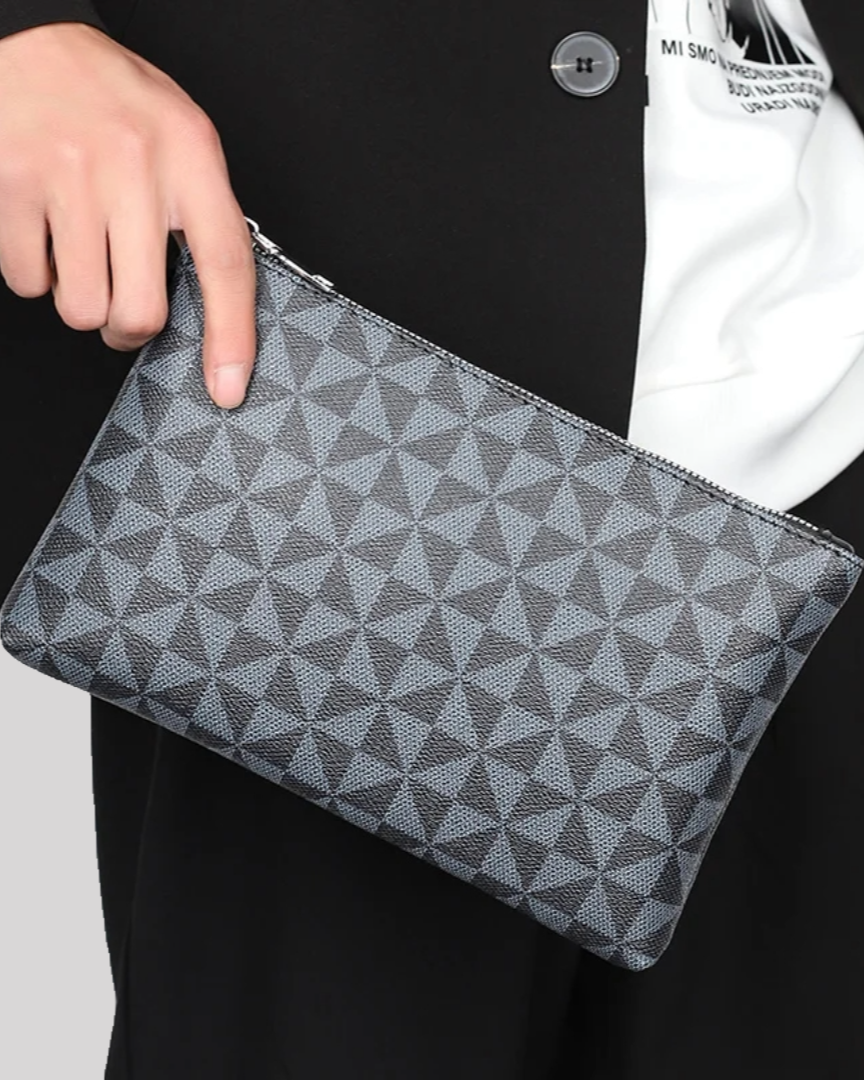 Angled handheld view of black wristlet pouch with repeating geometric print