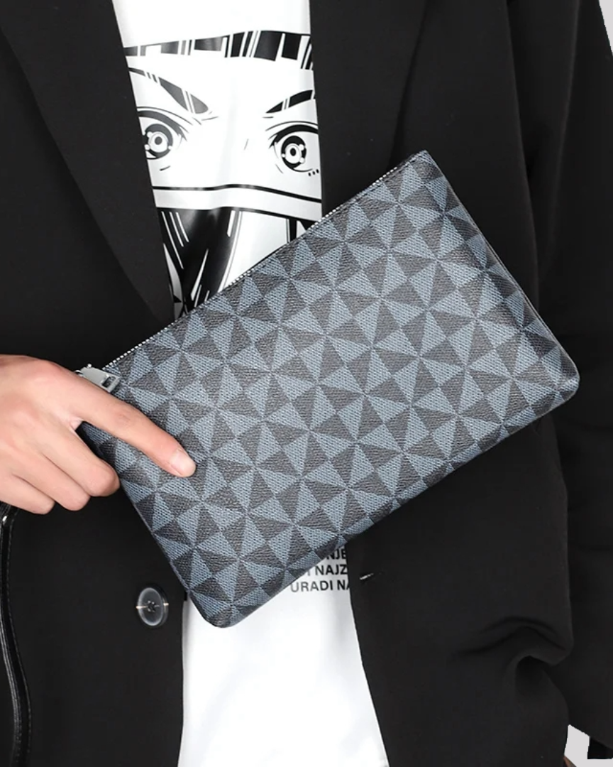 Close-up of black geometric wristlet pouch held in hand, showcasing textured pattern