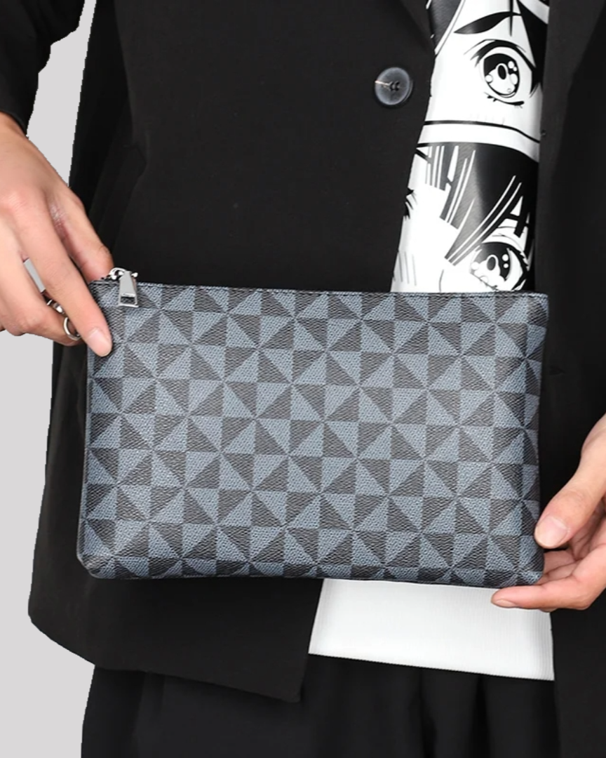 Handheld front view of black wristlet pouch with geometric design, paired with monochrome outfit