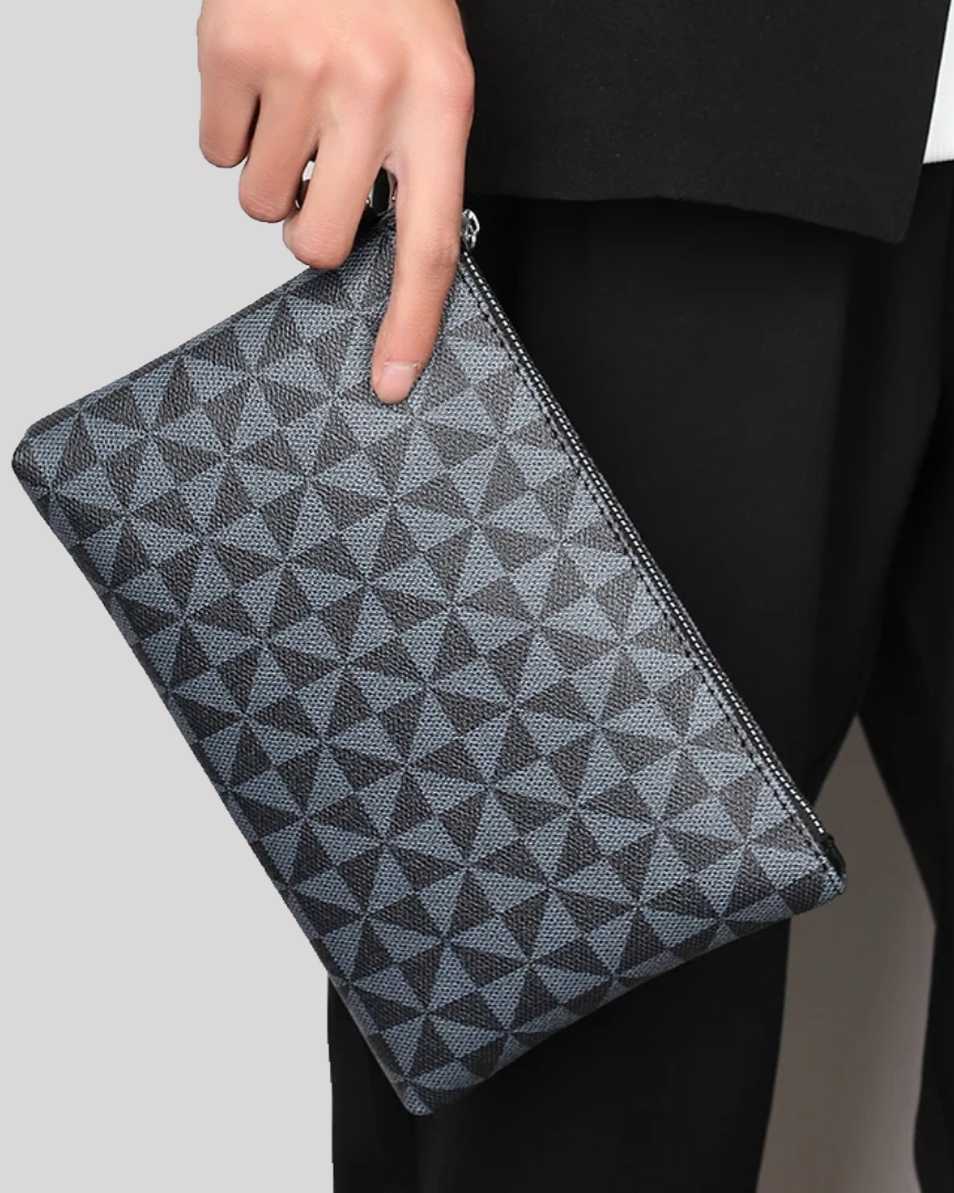 Side handheld view of black geometric wristlet pouch styled with a suit
