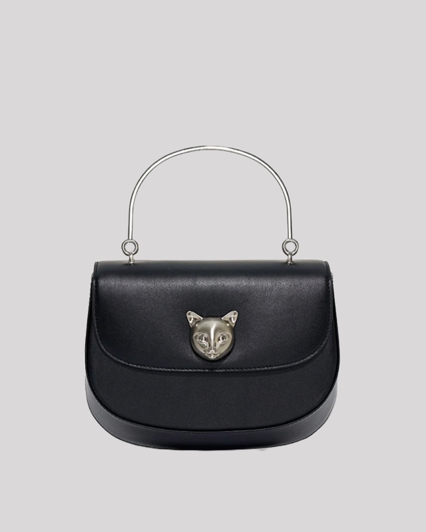 Front view of black leather handbag by Bafelli with embossed cat emblem and silver handle