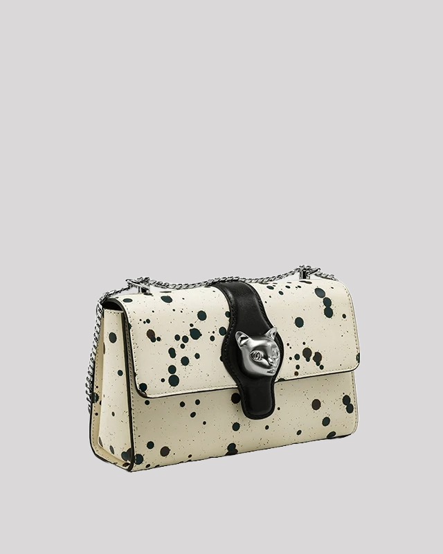 Side angle of black splatter paint shoulder bag with silver cat clasp and chain strap by Bafelli
