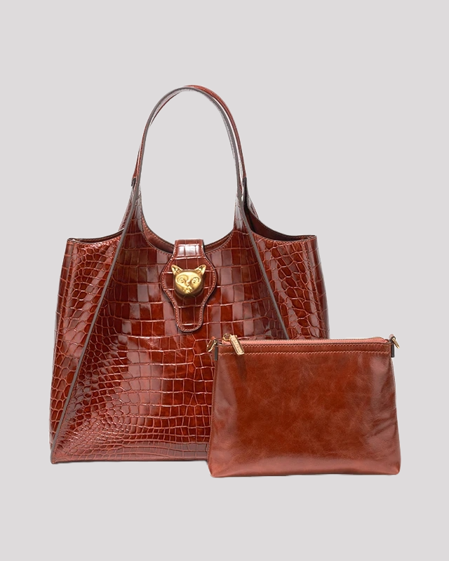 Brown croc-embossed tote bag by Bafelli with gold cat clasp, shown with matching leather pouch