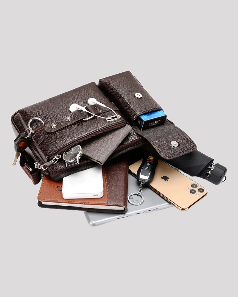 Brown leather messenger bag displayed open and filled with tablet, phone, keys, and accessories