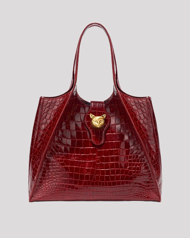Front view of burgundy crocodile embossed tote bag by Bafelli with gold cat-shaped lock