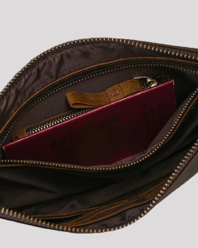 Dark brown leather clutch bag – interior view with passport inside zip pocket