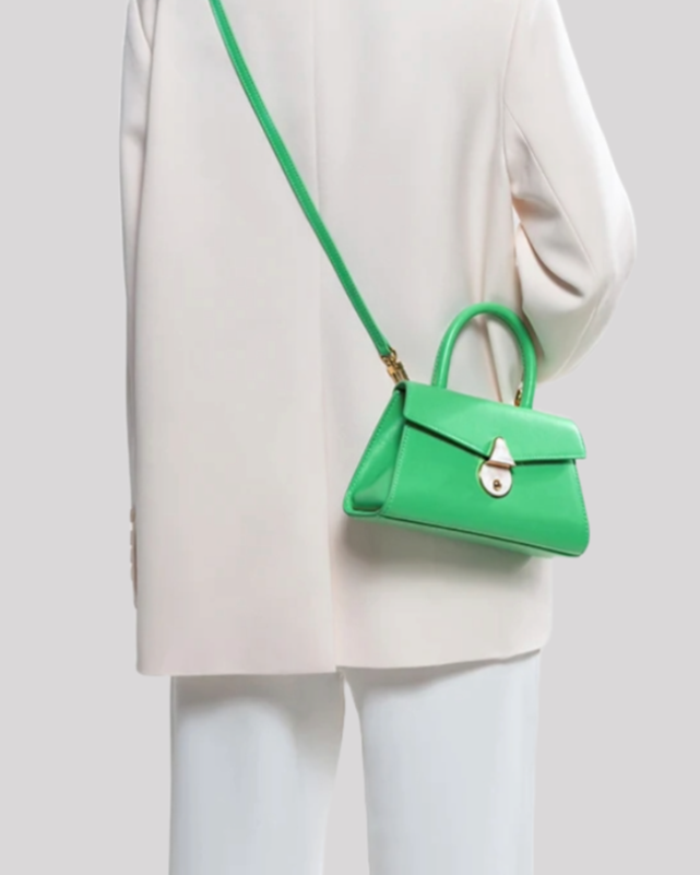 Green mini top-handle bag by Bafelli worn crossbody with detachable strap and pearl clasp detail