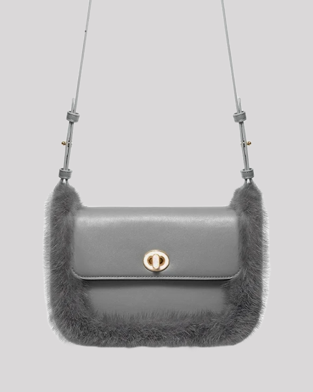 Hanging view of structured grey crossbody bag by Bafelli with fur trim and adjustable strap