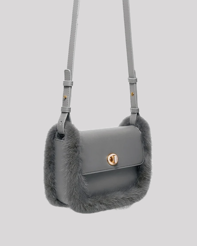 Side view of structured grey crossbody bag by Bafelli with fur trim and sleek silhouette
