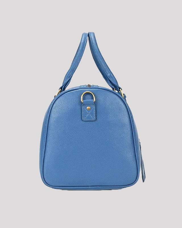 Back view of men’s blue leather travel duffle bag with gold hardware