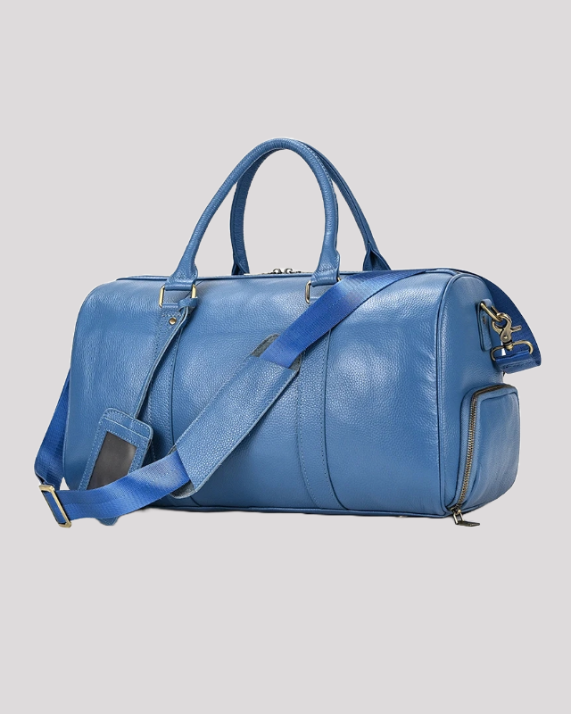 Men’s blue leather travel duffle bag with adjustable strap – side angle view