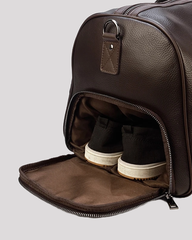 Men’s brown leather duffle bag – shoe compartment open with sneakers inside