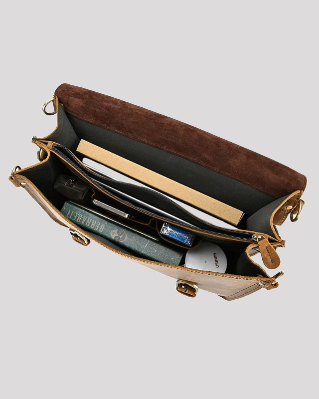 Open view of mocha leather messenger bag – spacious compartments with books and accessories
