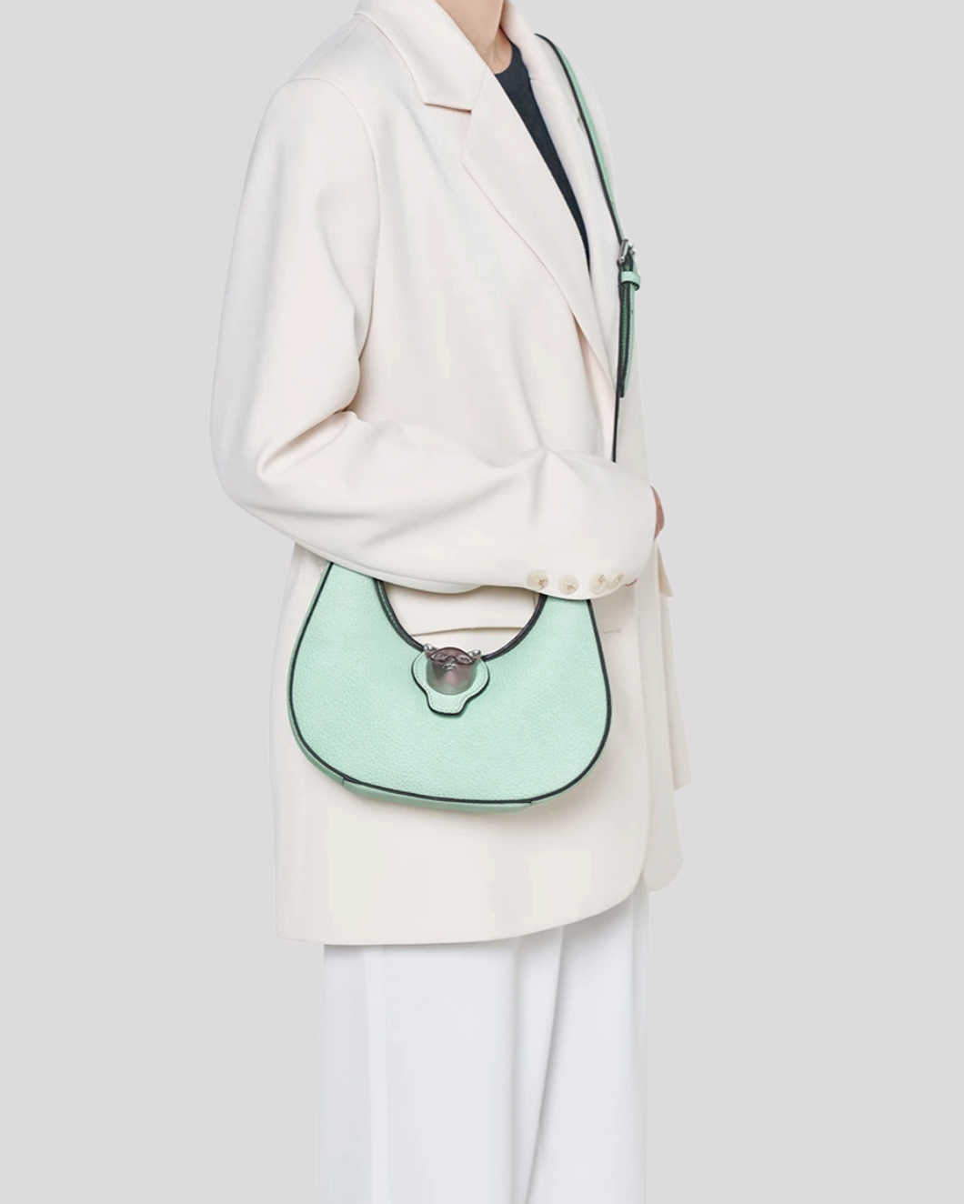 Woman wearing mint green leather shoulder bag by Bafelli with blazer – lifestyle view